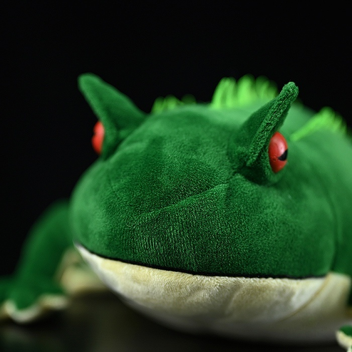 Close-up of Beelzebufo plush's lifelike face and bright red eyes, designed for prehistoric toy collectors