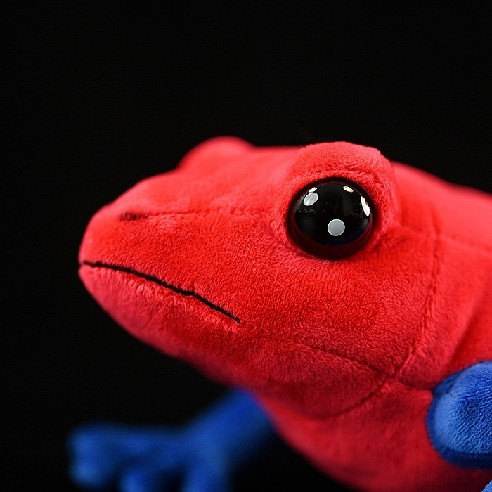 Close-up of Strawberry Poison Dart Frog plush’s face, featuring shiny black eyes and realistic details