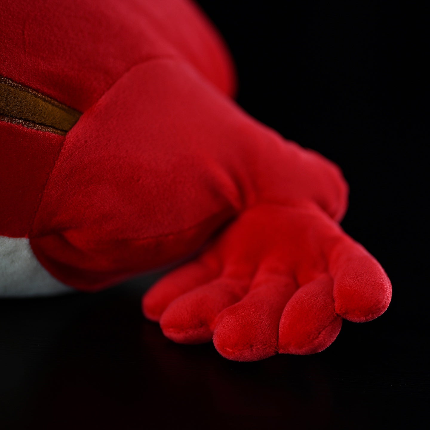 Close-up of Madagascar Tomato Frog plush’s vibrant red hand, showcasing its soft and squishy texture