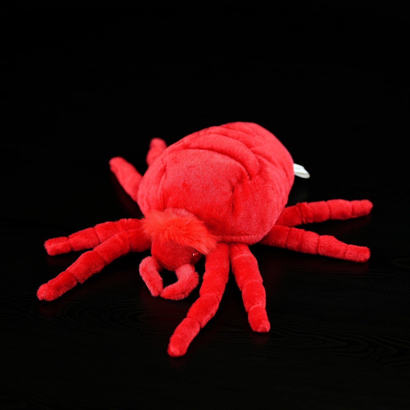 Top-down view of red velvet mite plush toy, featuring realistic details and soft, vibrant texture