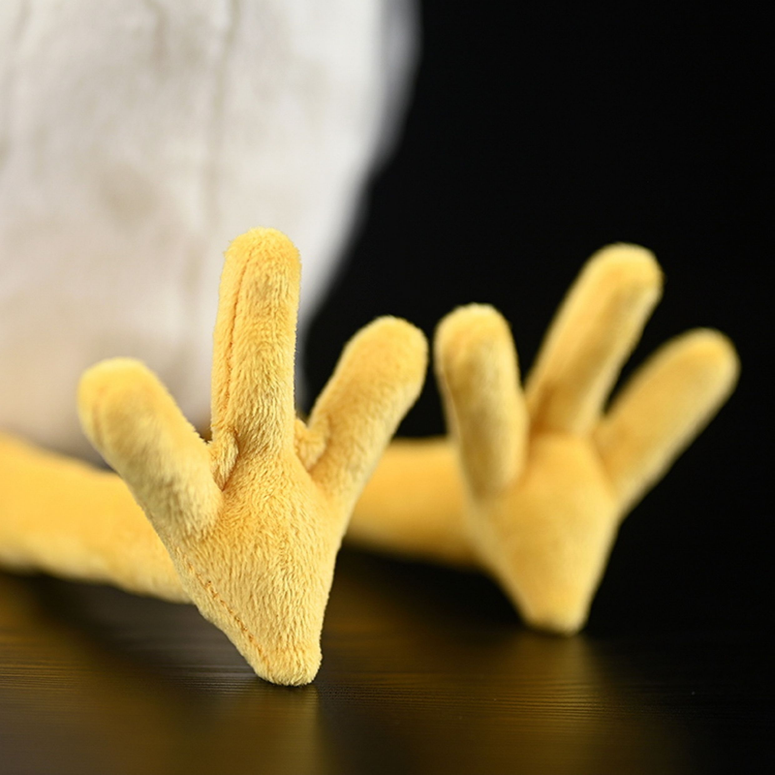 Close-up of the yellow plush feet of a Black-crowned Night Heron toy, ideal for realistic animal plush collectors