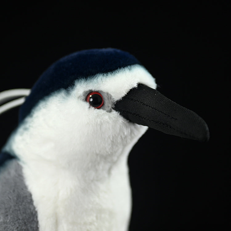 Close-up of the black-crowned night heron plush face, highlighting its realistic beak and red eyes