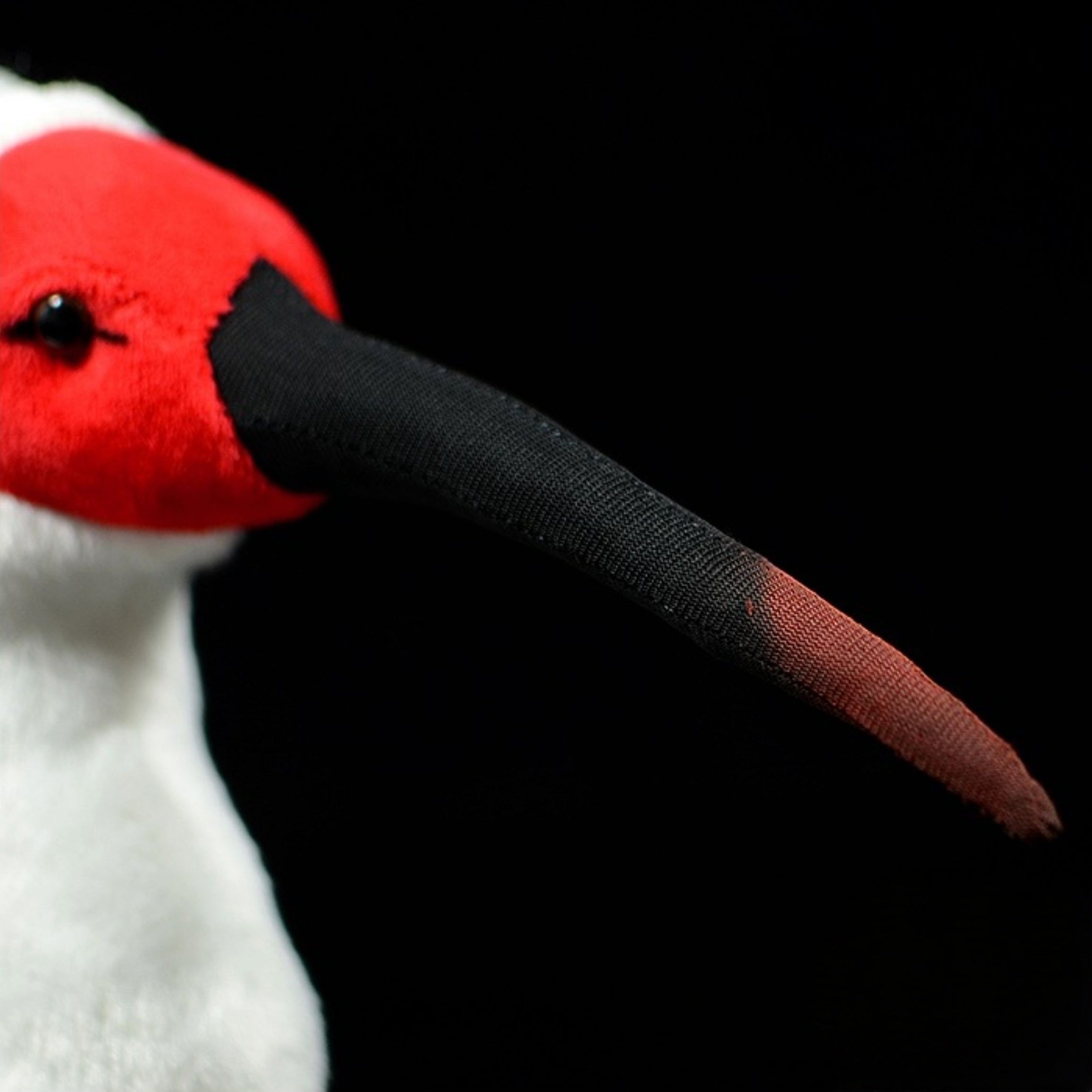 Close-up of Asian crested ibis plush toy's detailed curved black and red beak, designed for true-to-life appearance