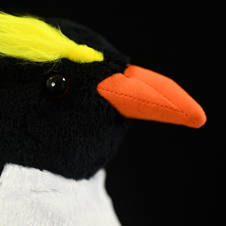 Close-up of a Fiordland penguin plush face with vivid yellow crests and shiny eyes, crafted by SoftDaysLab
