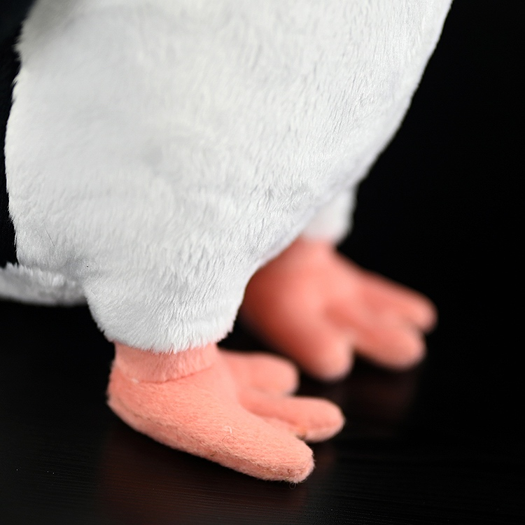 Detailed view of lifelike Fiordland penguin plush's feet with soft pink fabric, adding a realistic touch