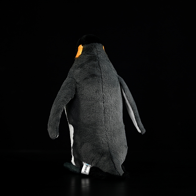 Rear view of a king penguin stuffed toy highlighting detailed dark grey back and smooth plush material