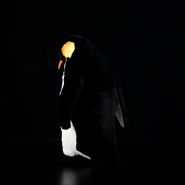 Back view of realistic emperor penguin plush toy in a standing pose, featuring vibrant yellow and black plumage