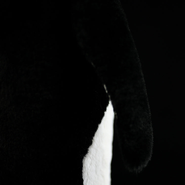 Close-up of an emperor penguin plush toy's wing, highlighting its soft, lifelike black fabric and detailed design