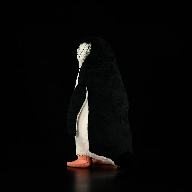 Rear view of a chinstrap penguin plush toy, highlighting its soft tail and realistic black-and-white coloring