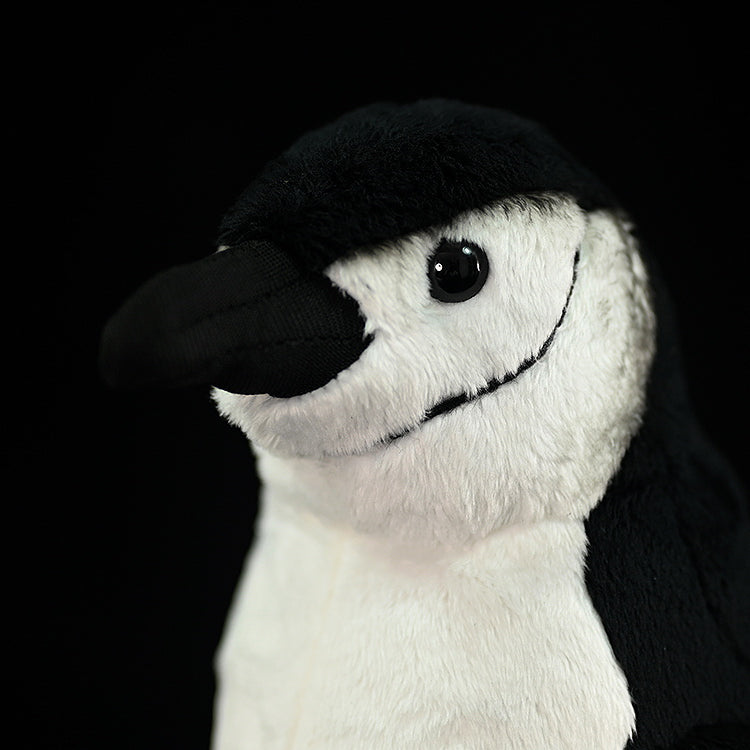 Close-up of a chinstrap penguin plush toy’s face, showcasing its realistic stitching and lifelike expression