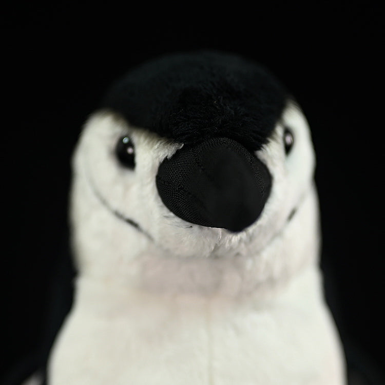 Front close-up of a chinstrap penguin plush toy’s beak and eyes, emphasizing its lifelike design and soft materials