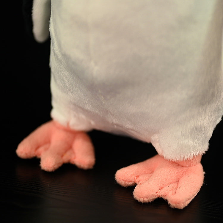 Close-up of the feet of a chinstrap penguin plush toy, featuring soft pink fabric and realistic detail