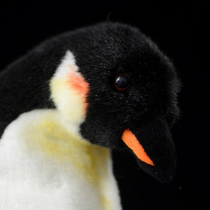 Close-up of Mom & Baby emperor penguin plush face, showcasing lifelike details and bright orange beak