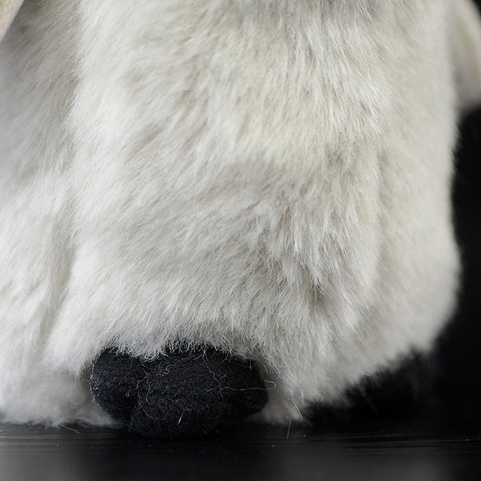 Bottom view of plush emperor penguin chick's feet, highlighting lifelike design and soft materials