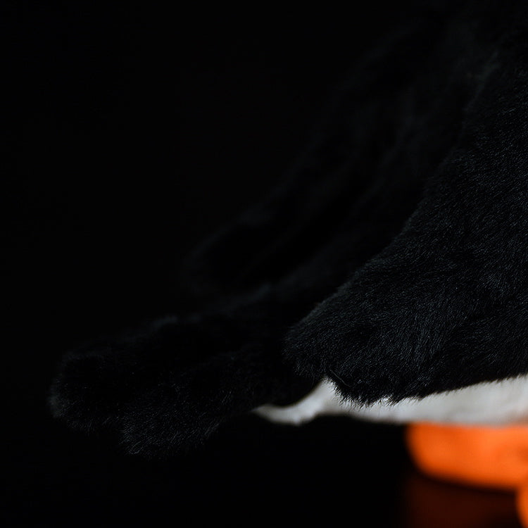 Close-up of the tail feathers of lifelike Atlantic puffin plush toy with soft black fabric