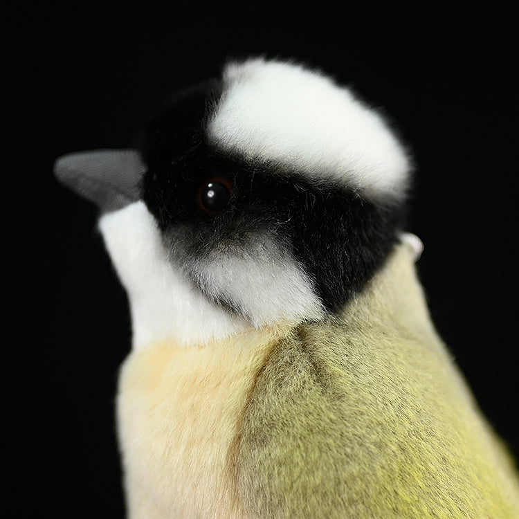 Close-up of the side profile of a light-vented bulbul plush, showing its detailed head and soft texture