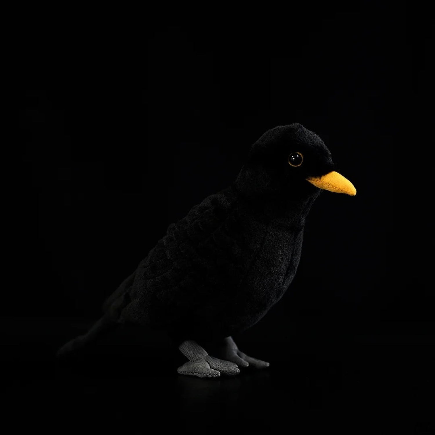 Eurasian Blackbird plush toy with soft black fur, a bright yellow beak, and realistic stitched details