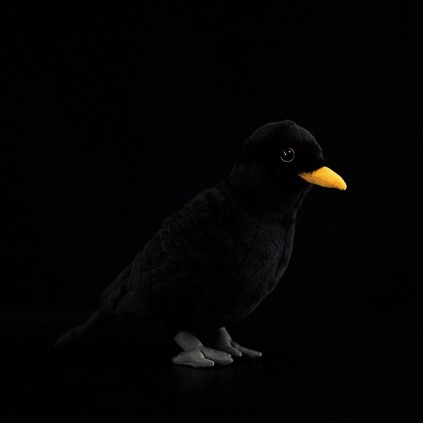 Eurasian Blackbird plush toy with soft black fur, a bright yellow beak, and realistic stitched details