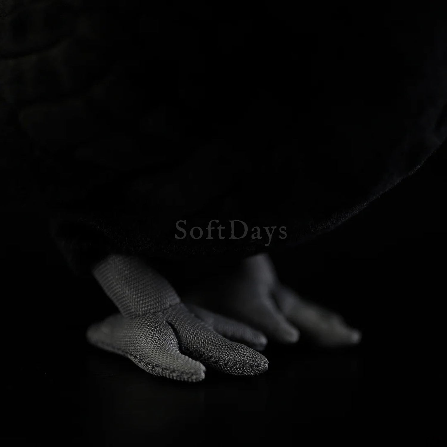 Close-up of the Eurasian Blackbird plush toy's gray feet with realistic stitching and soft texture