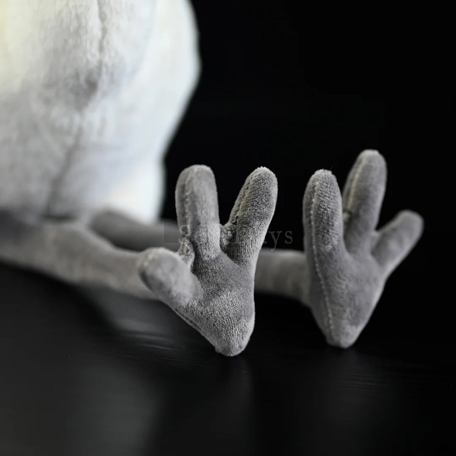 Close-up of Chinese Egret bird plush toy's soft gray feet with detailed design and lifelike texture