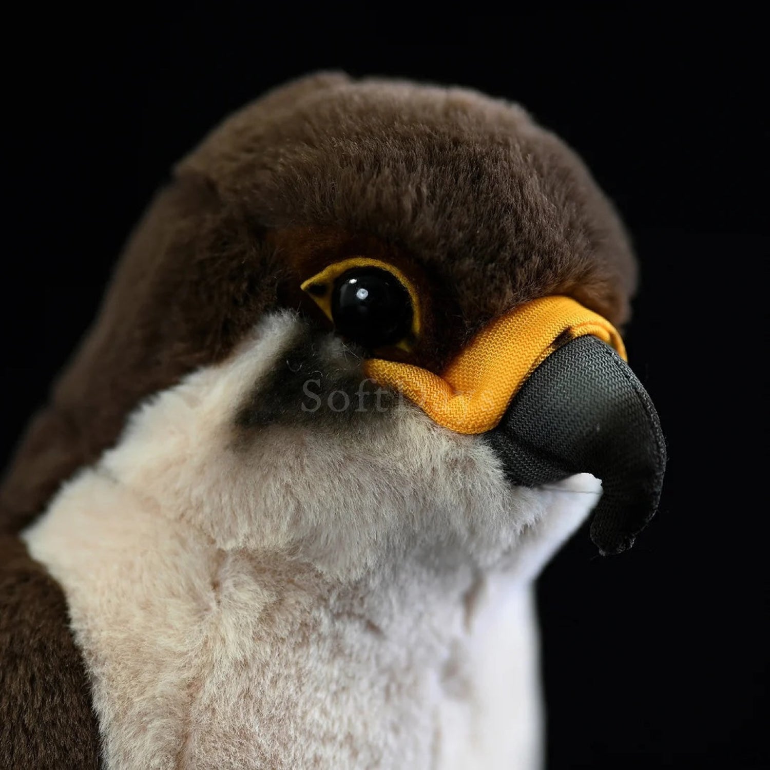 Close-up of peregrine falcon plush toy highlighting lifelike black beak and expressive yellow eyes