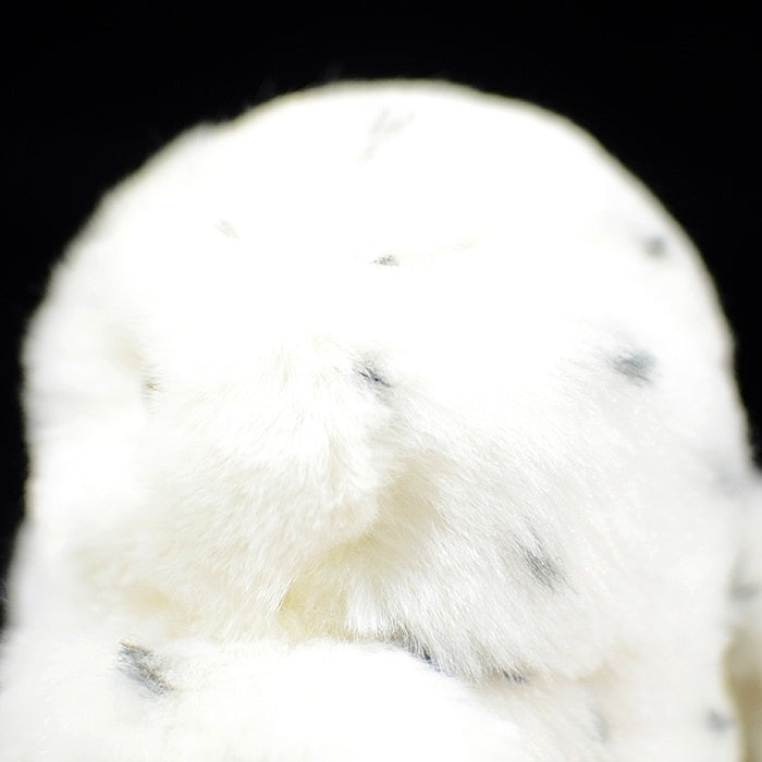 Top view of snowy owl plush toy, showing its soft fur and intricate black speckles for added realism
