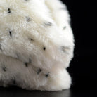 Detailed side of realistic snowy owl plush toy, featuring soft fur and lifelike feather patterns