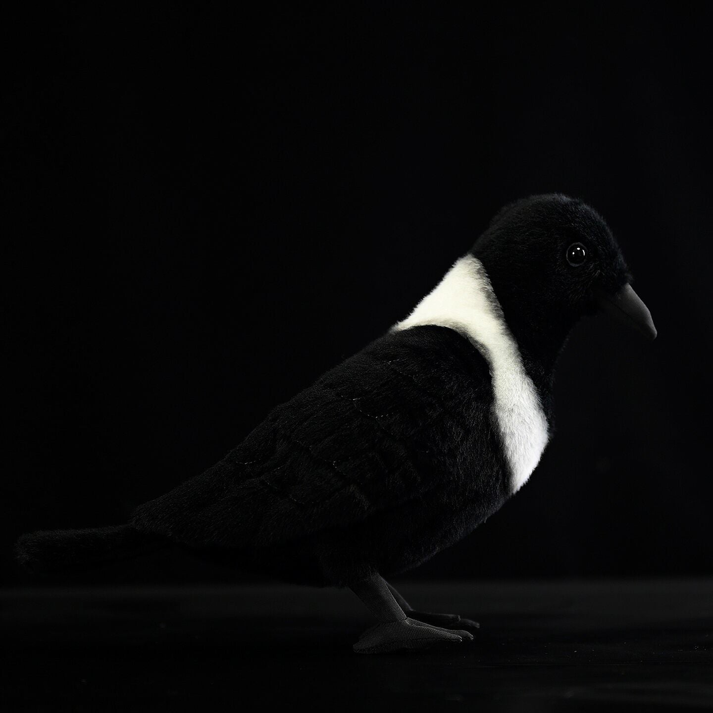 Left-side profile of a realistic Collared Crow plush toy with soft textures and detailed wings