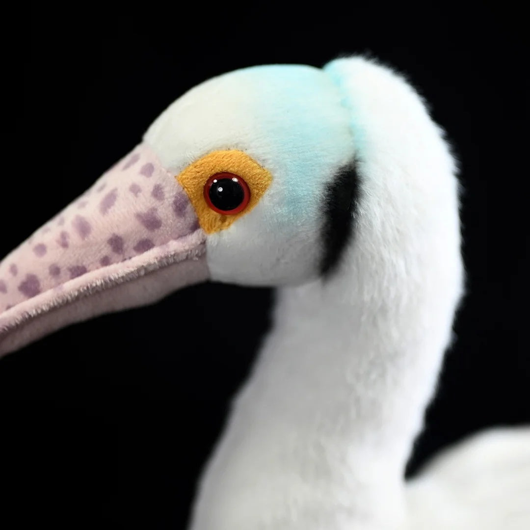 Detailed shot of Roseate Spoonbill plush’s head, featuring vivid eye details and soft fabric
