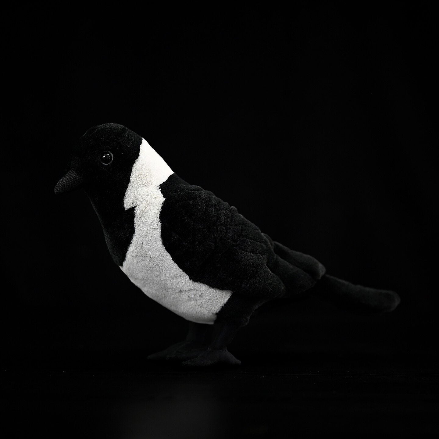 Side profile of a lifelike Daurian Jackdaw plush toy featuring authentic design and soft texture