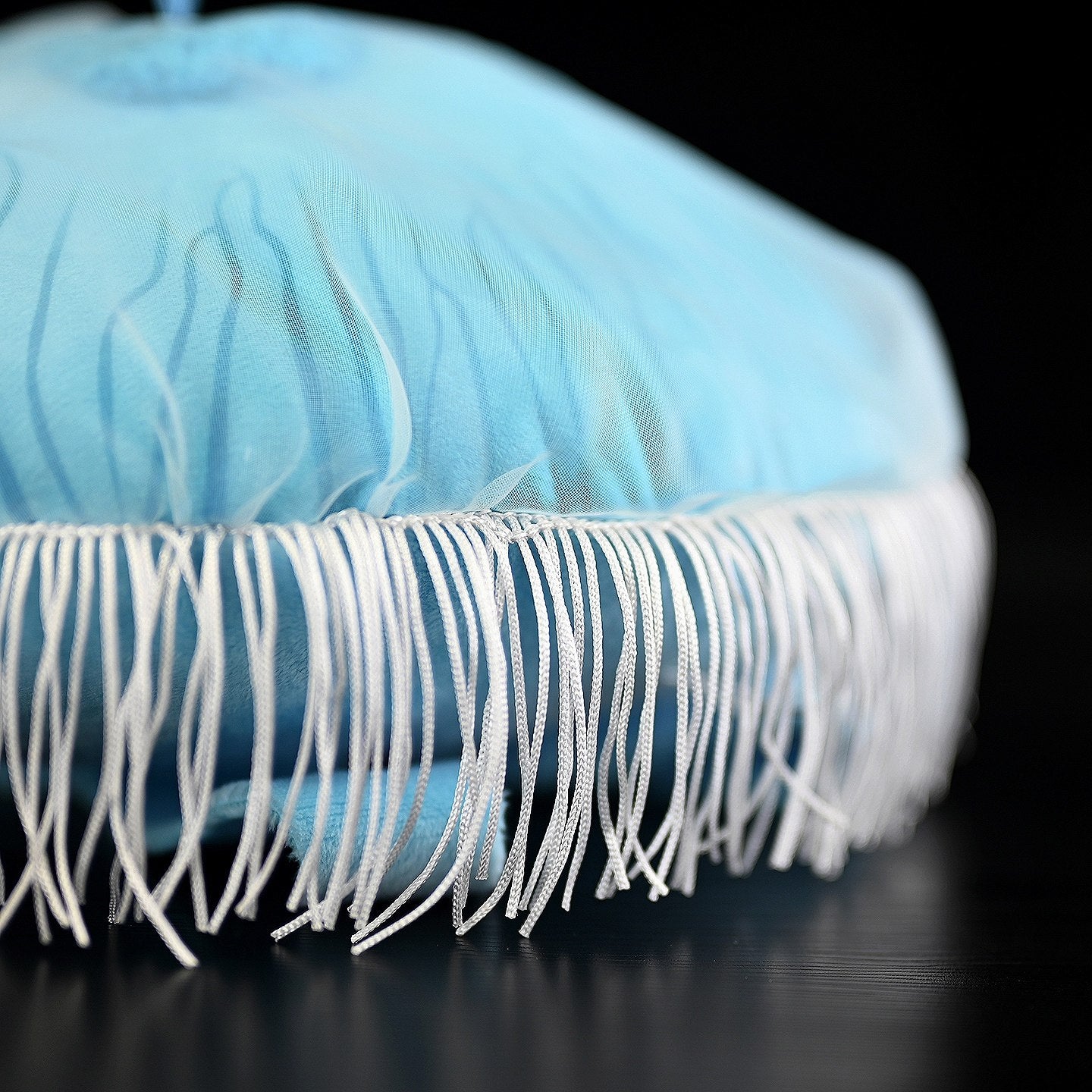 Side view of the Moon Jellyfish Plush's fringe and soft fabric texture, resembling the beauty of Aurelia aurita