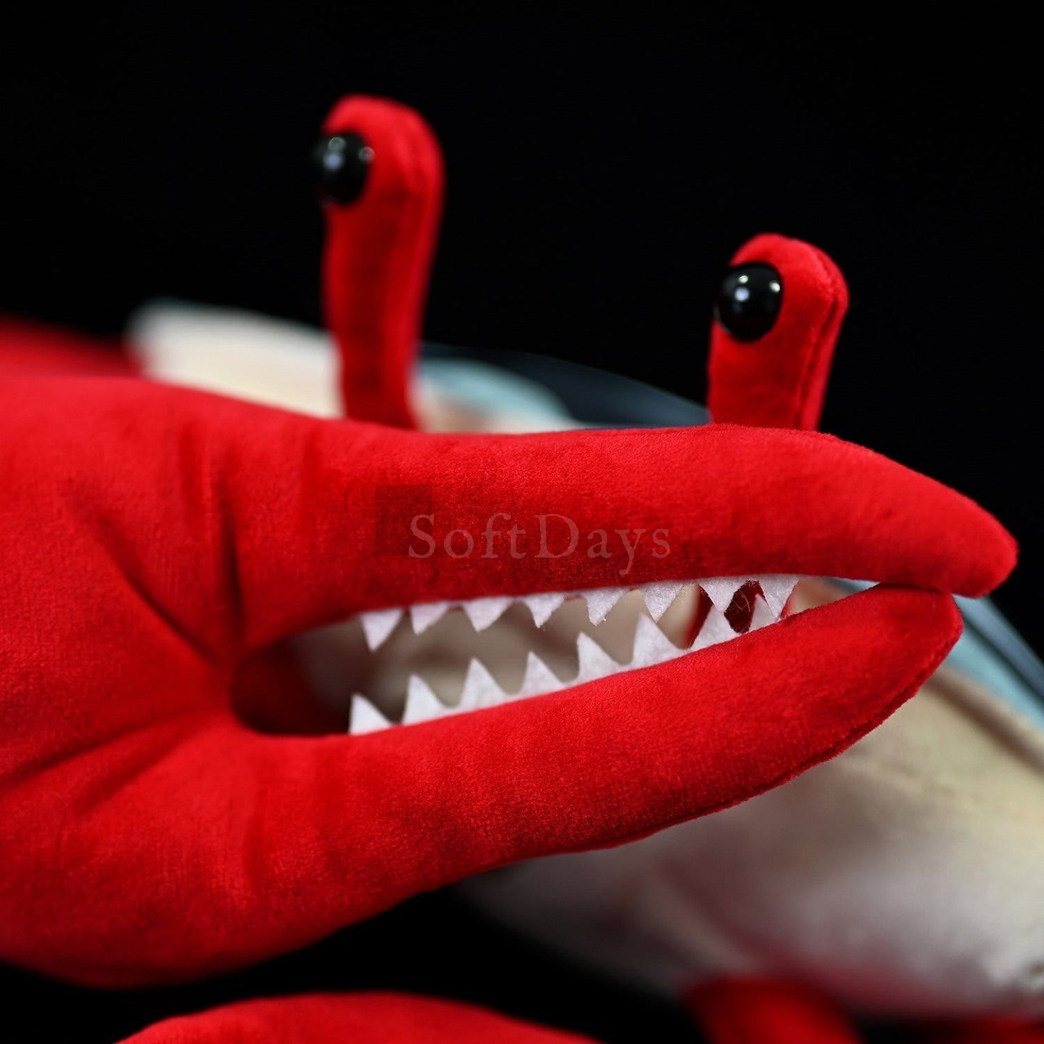 Close-up of the large red claw on fiddler crab plush toy with soft fabric and lifelike design for nature lovers