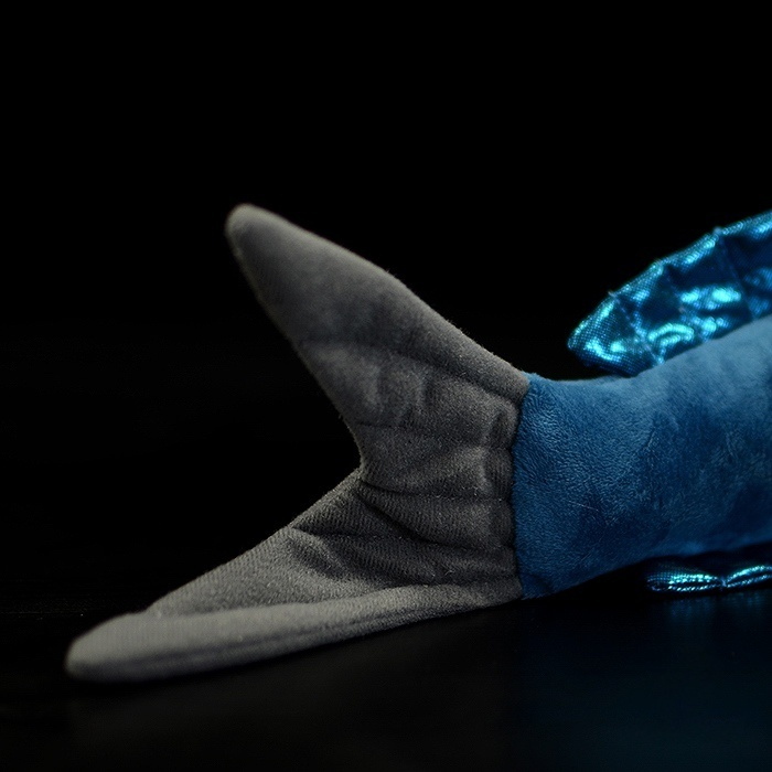 Close-up of the shimmering blue wings of a flying fish plush toy, capturing fine details