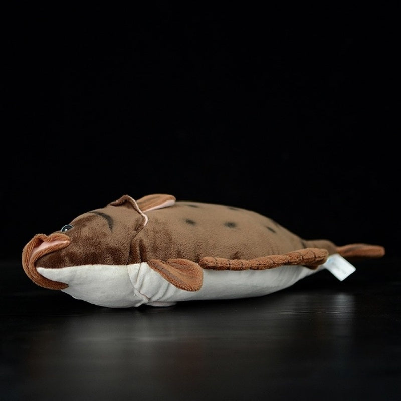 Side view of flounder flatfish plush toy, showcasing its realistic spotted design and soft texture