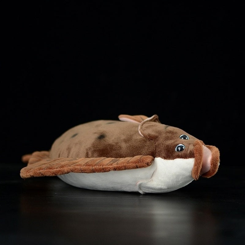 Profile view of flounder flatfish plush, showcasing its flat body and soft high-quality materials