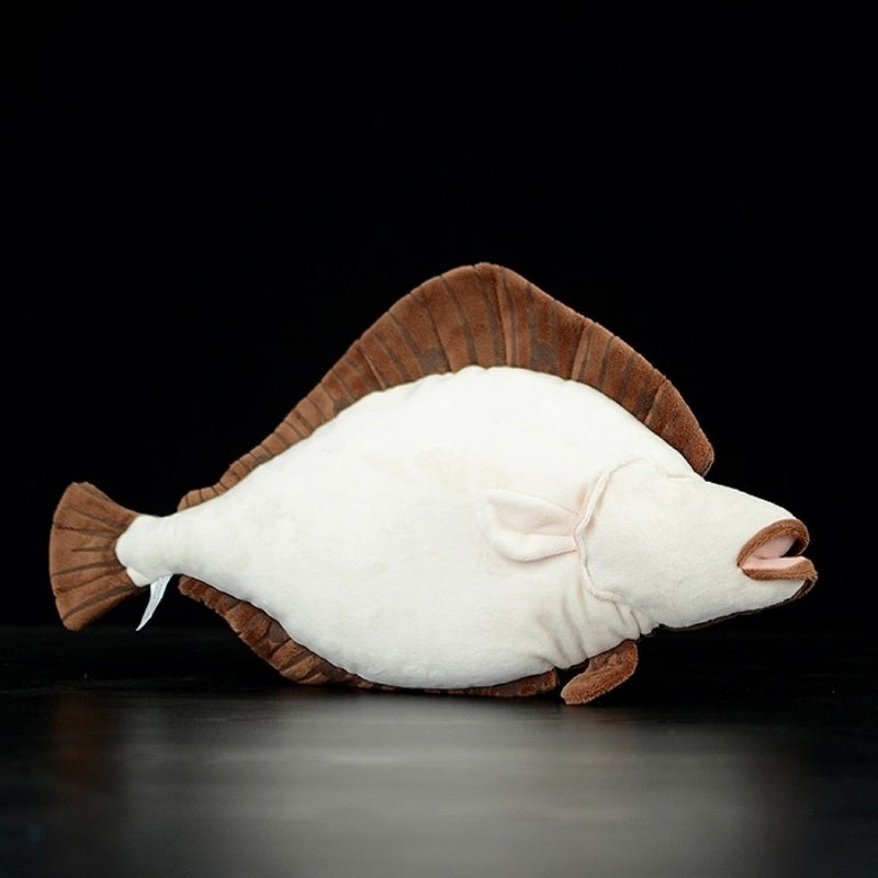 Underside view of lifelike flatfish stuffed animal, highlighting its white belly and detailed stitching