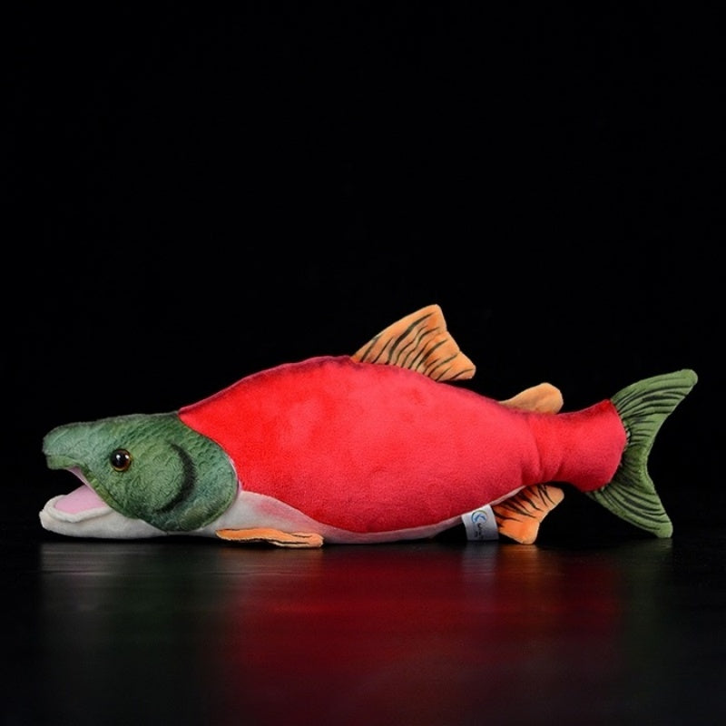 Side view of the sockeye salmon plush toy, highlighting its vivid spawning colors and soft texture