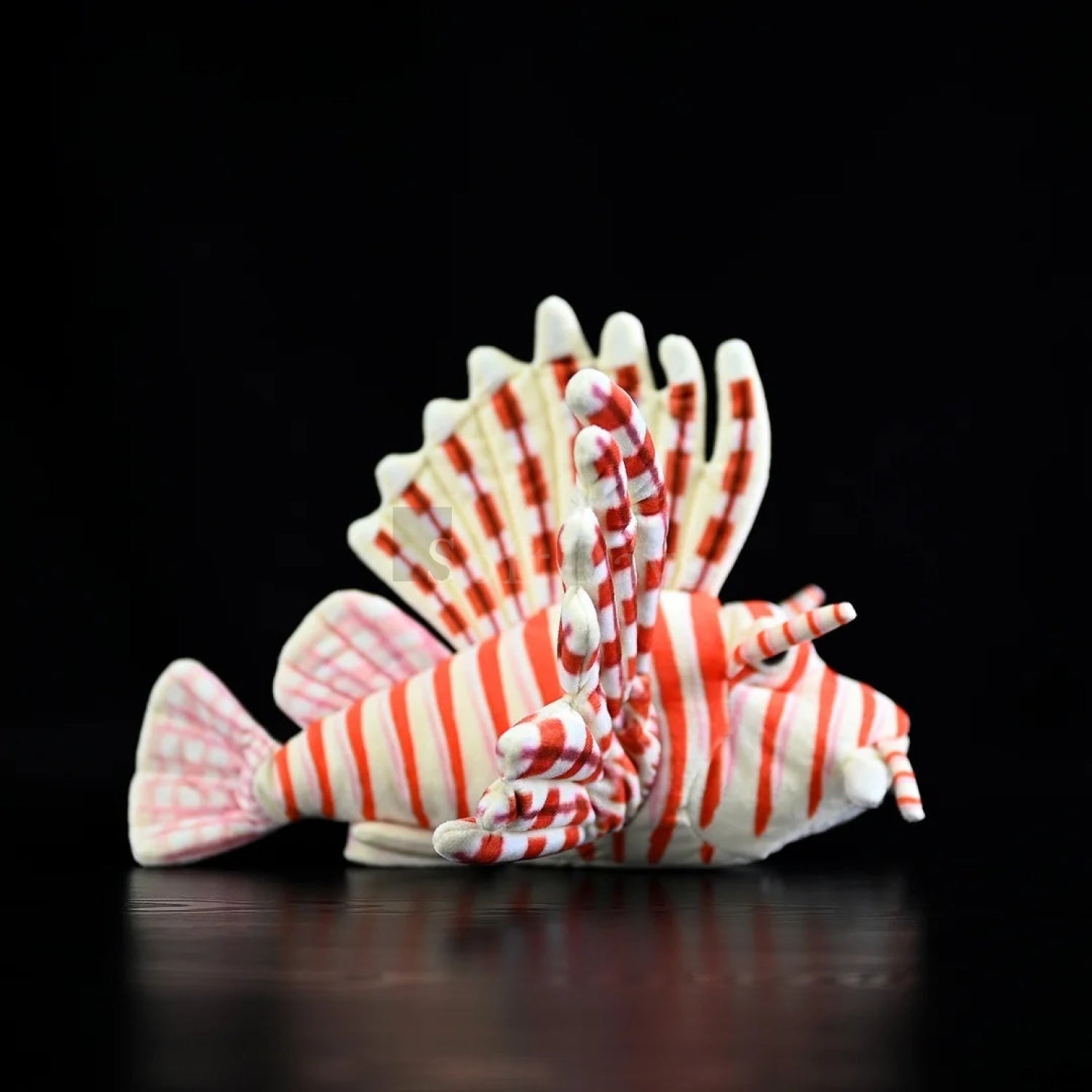 Side view of red lionfish plush toy displaying flowing fins and bold red-and-white stripes