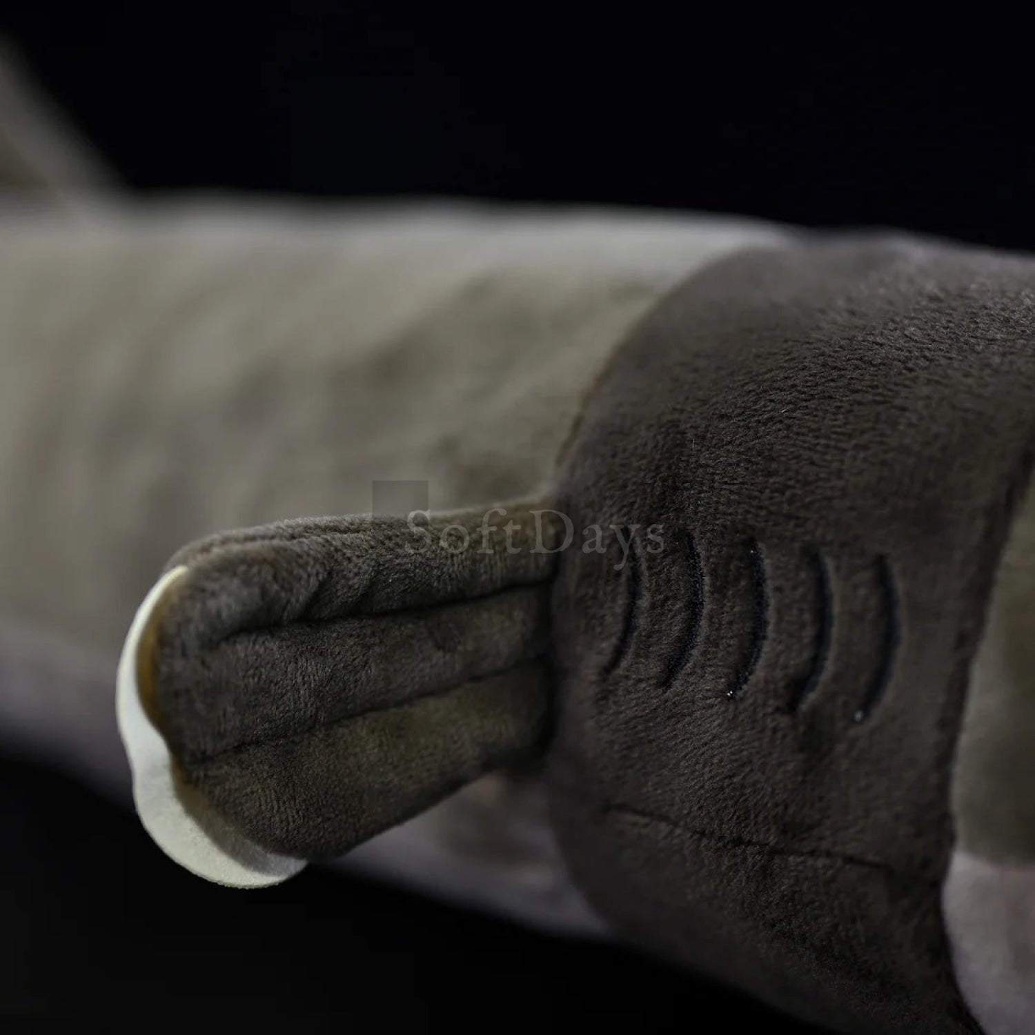 Close-up of lifelike cookiecutter shark plush toy’s fin with detailed stitching and soft texture