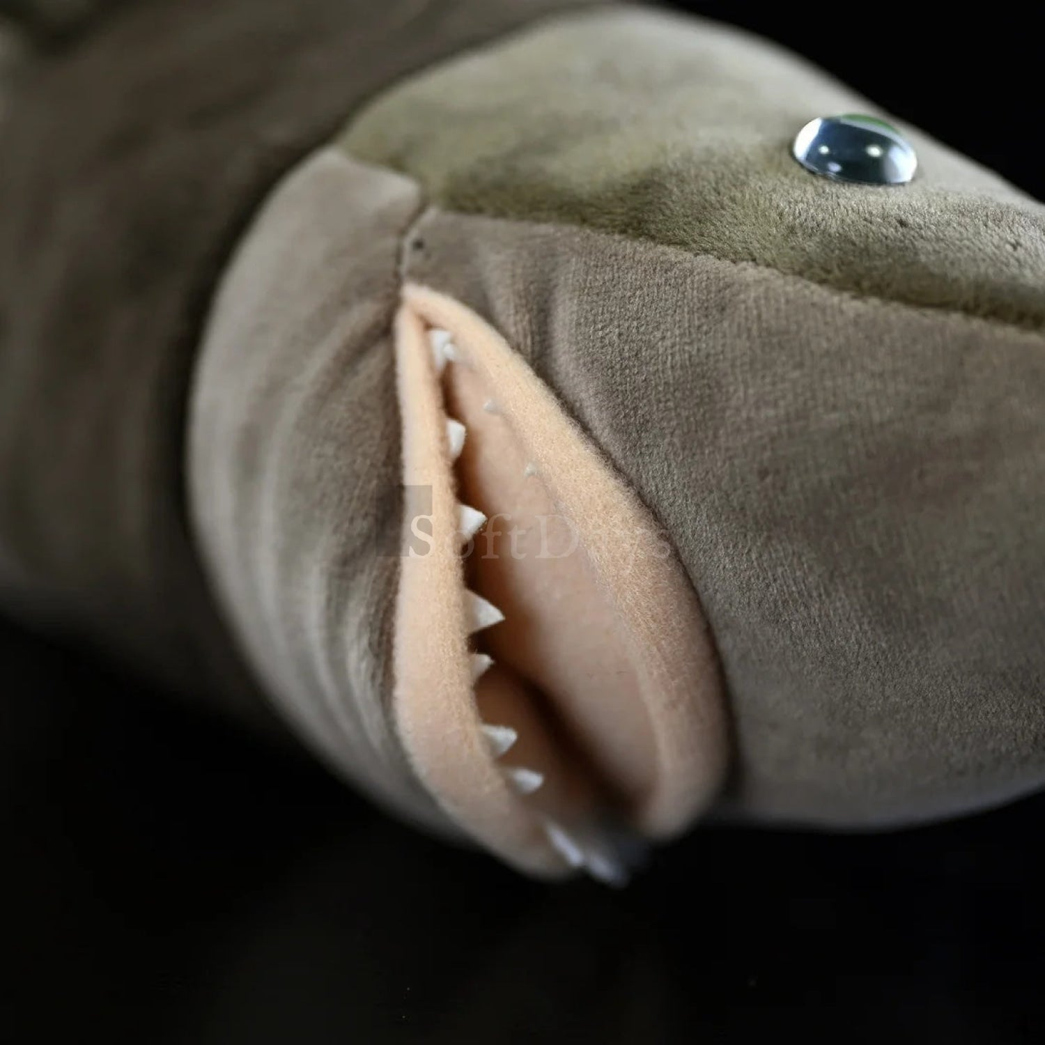 Close-up of cookiecutter shark plush toy’s sharp teeth and lifelike mouth design