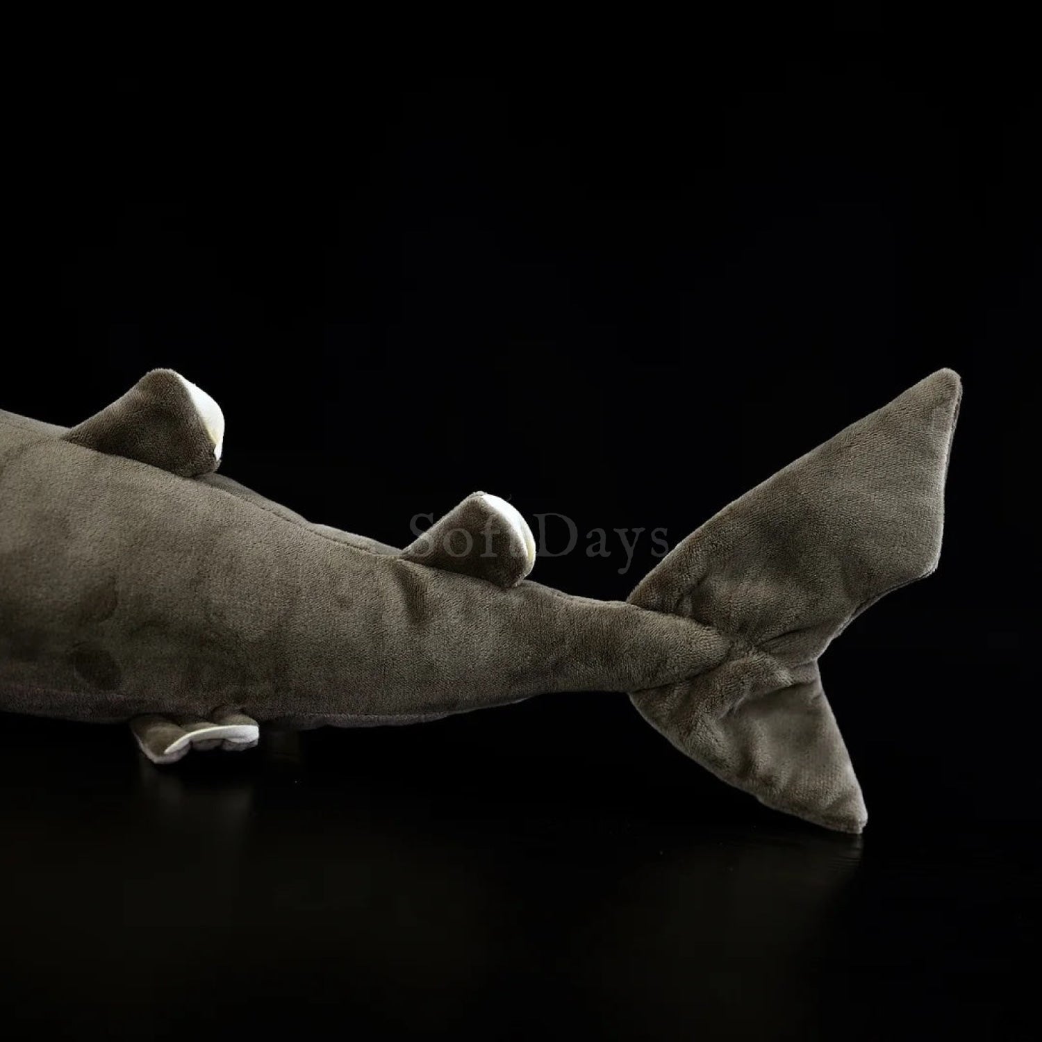 Close-up of cookiecutter shark plush toy’s tail, featuring lifelike design and soft, textured fabric