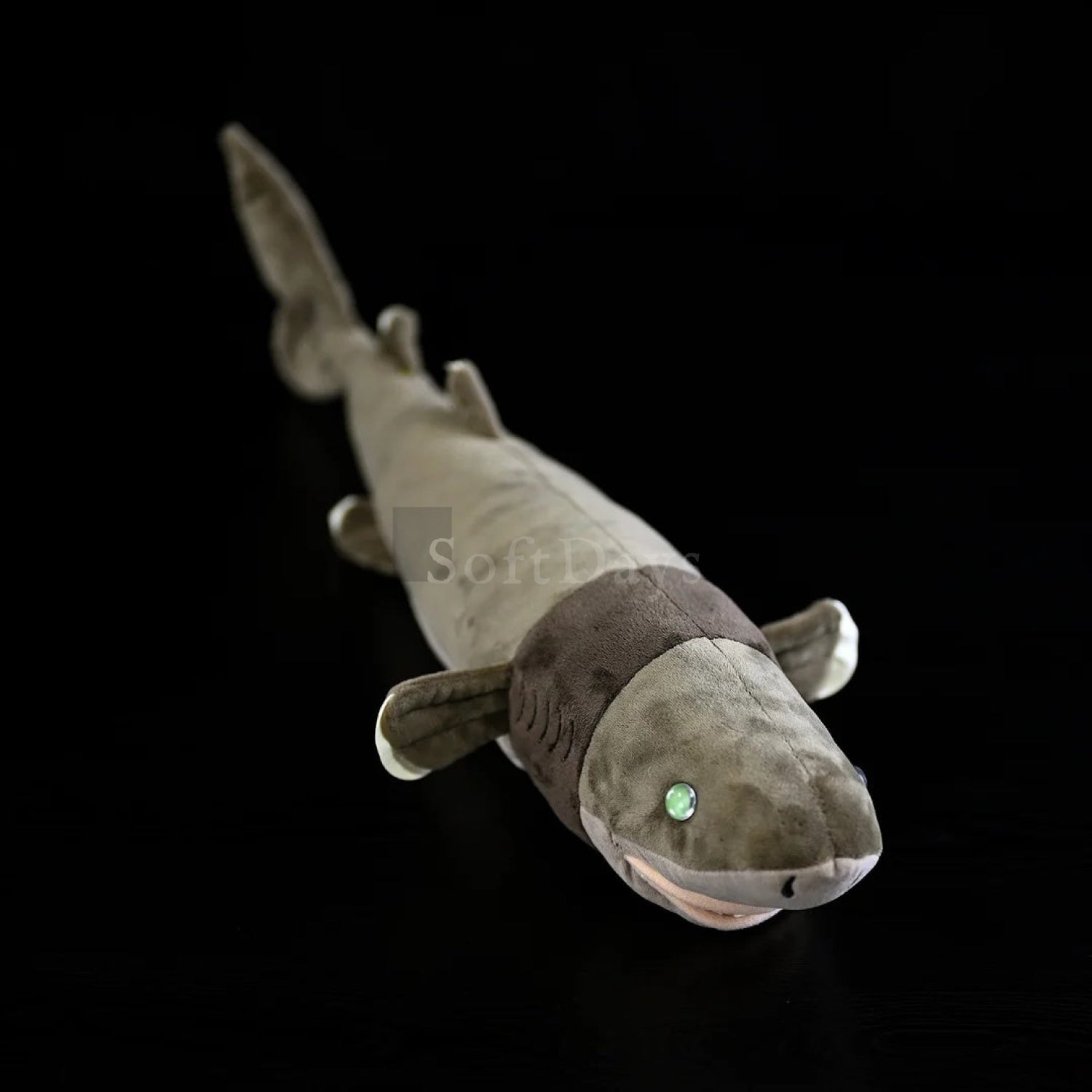 Realistic cookiecutter shark plush toy with lifelike design, glowing green eyes, and soft texture