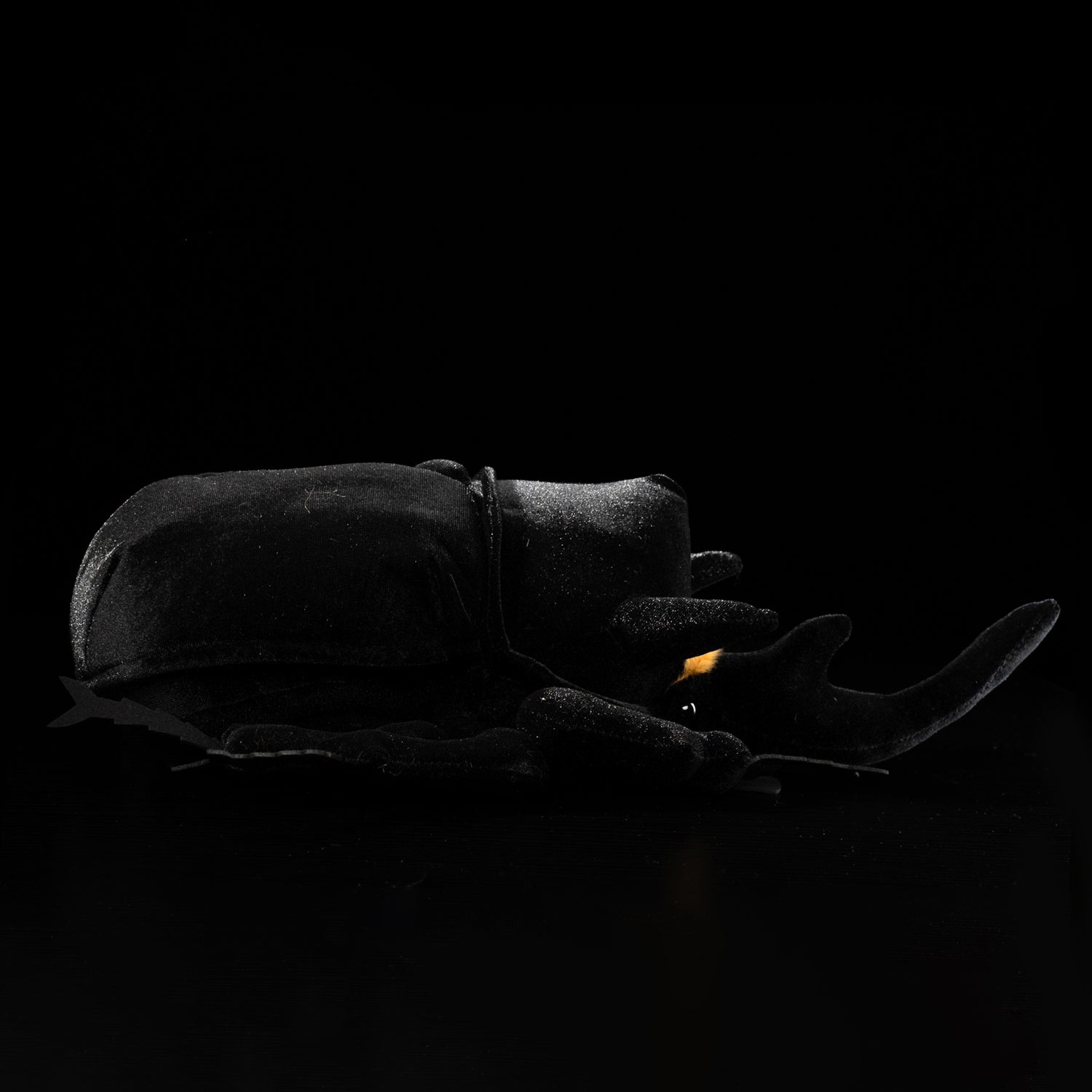 Side view of a realistic Mars rhino beetle plush toy with lifelike horns and black body by SoftDaysLab