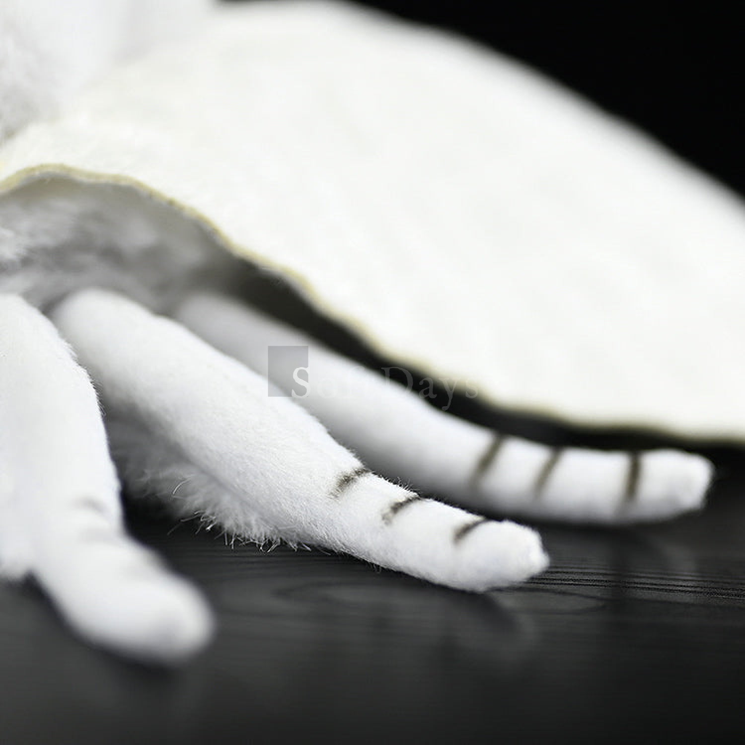 Close-up of Fall Webworm Moth plush's striped legs and soft body, showcasing its detailed craftsmanship