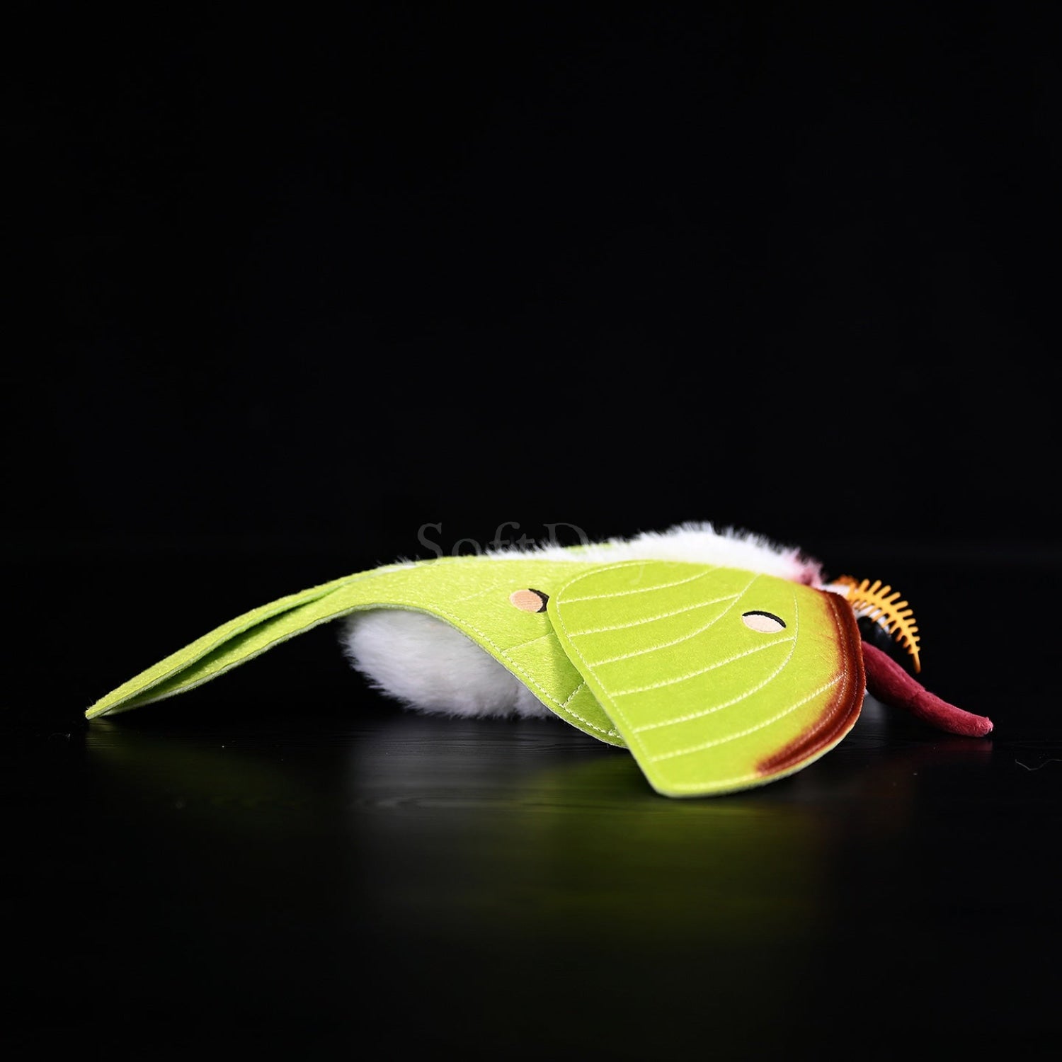 Side view of Indian Moon Moth plush emphasizing its fluffy white body and realistic wing design