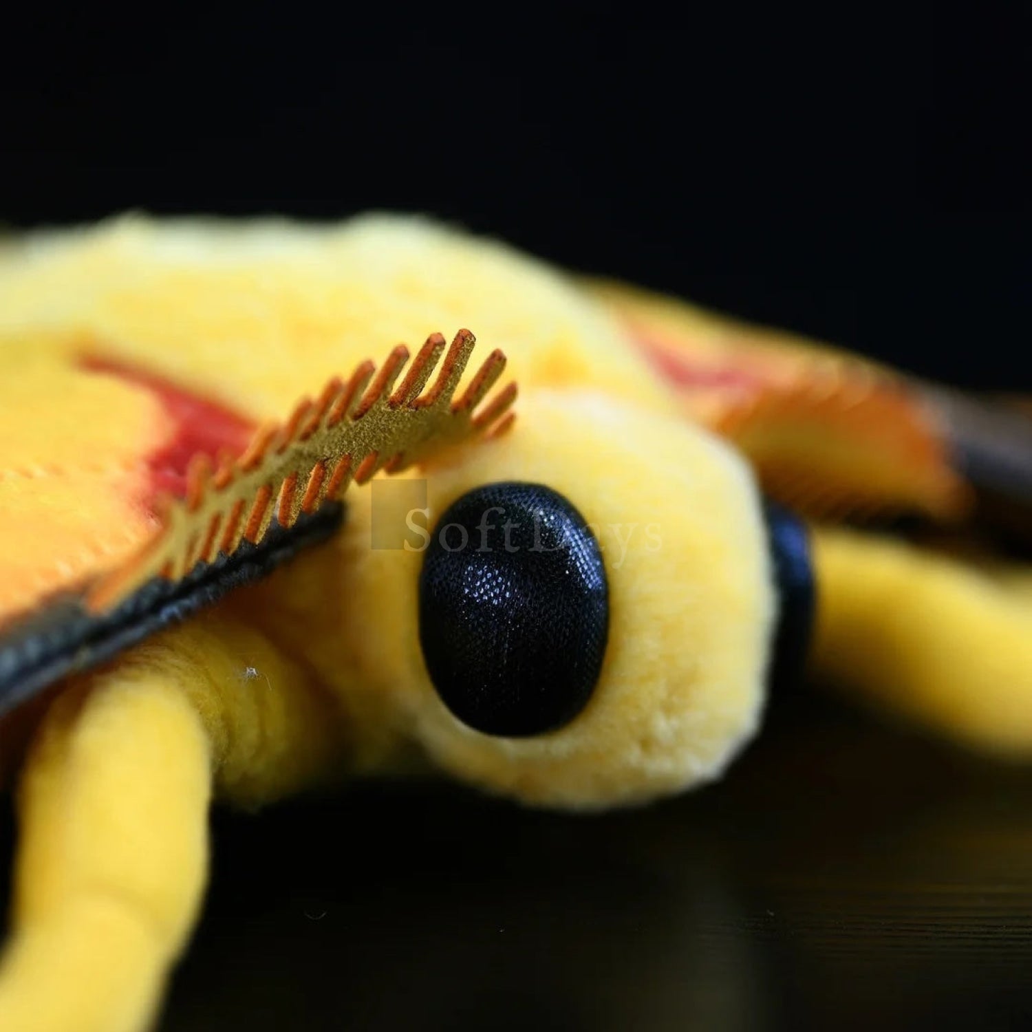 Close-up of comet moth plush head, featuring intricate antennae and lifelike black eyes