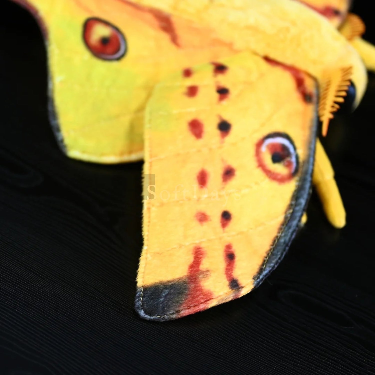 Detailed view of comet moth plush wing, featuring vibrant patterns and lifelike craftsmanship