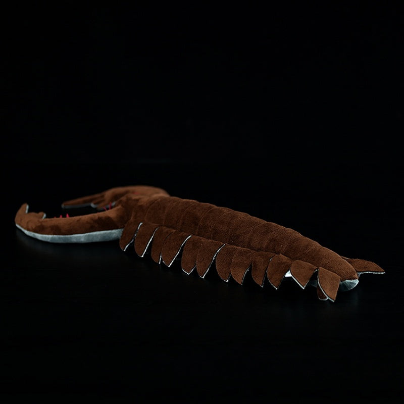 Back view of the Omnidens plush toy, emphasizing its segmented flaps and unique prehistoric design