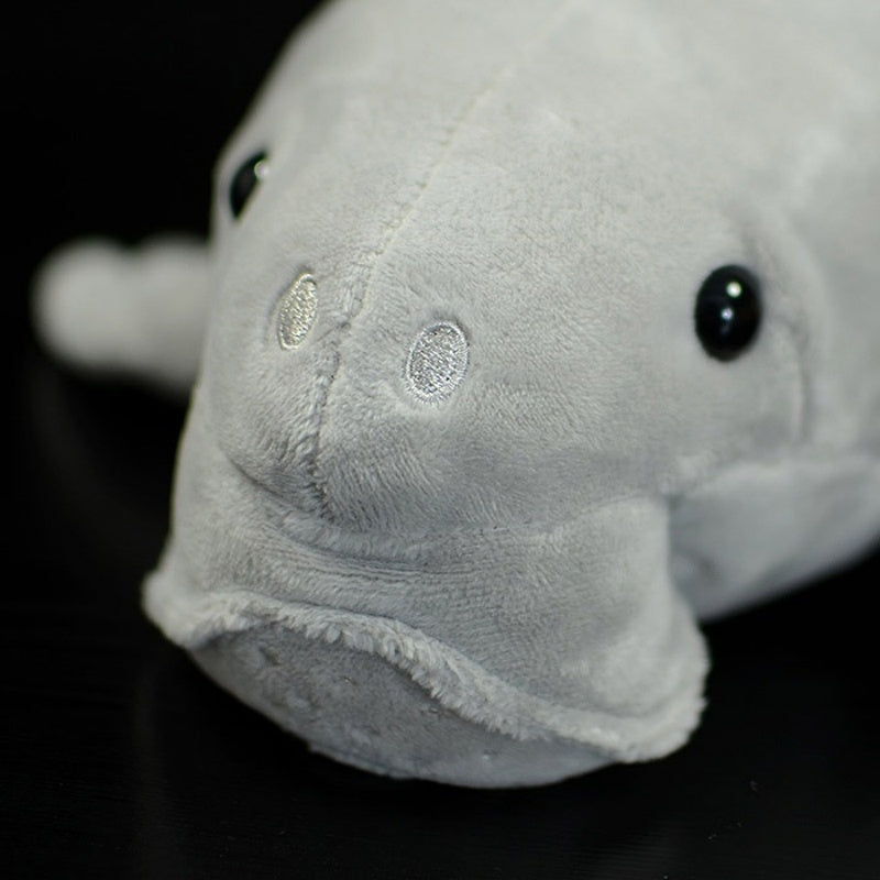 Close-up of the dugong plush toy's head, showing fine stitching and realistic eyes