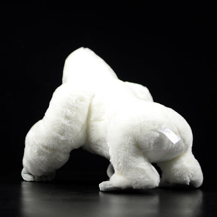 Back view of a white gorilla stuffed animal, highlighting its fluffy texture and lifelike posture